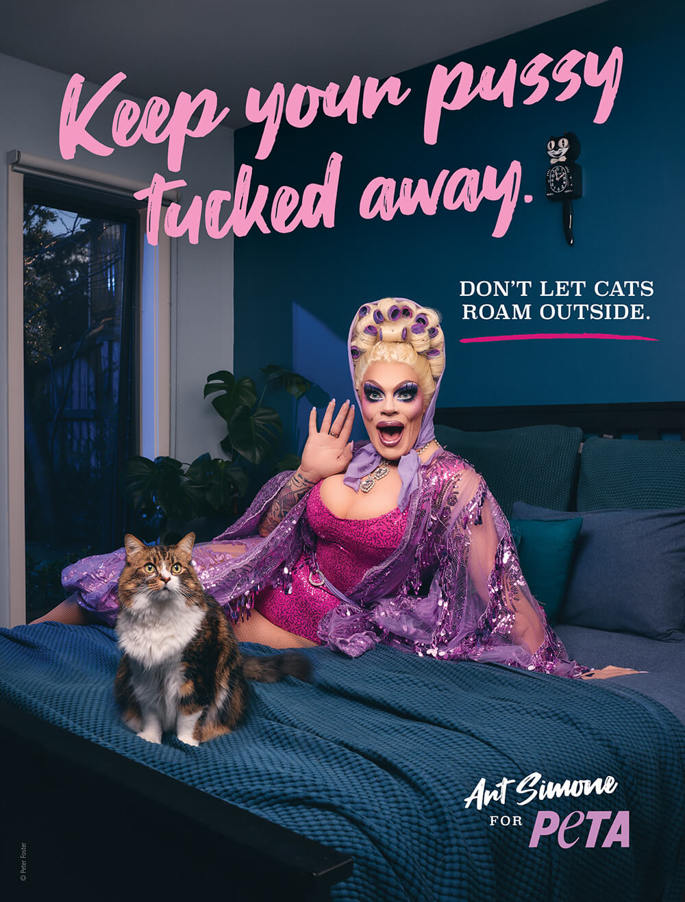 Drag Queen Art Simone lounges on a bed with a cat. Text reads: "Keep your pussy tucked away. Don't let cats roam outside."