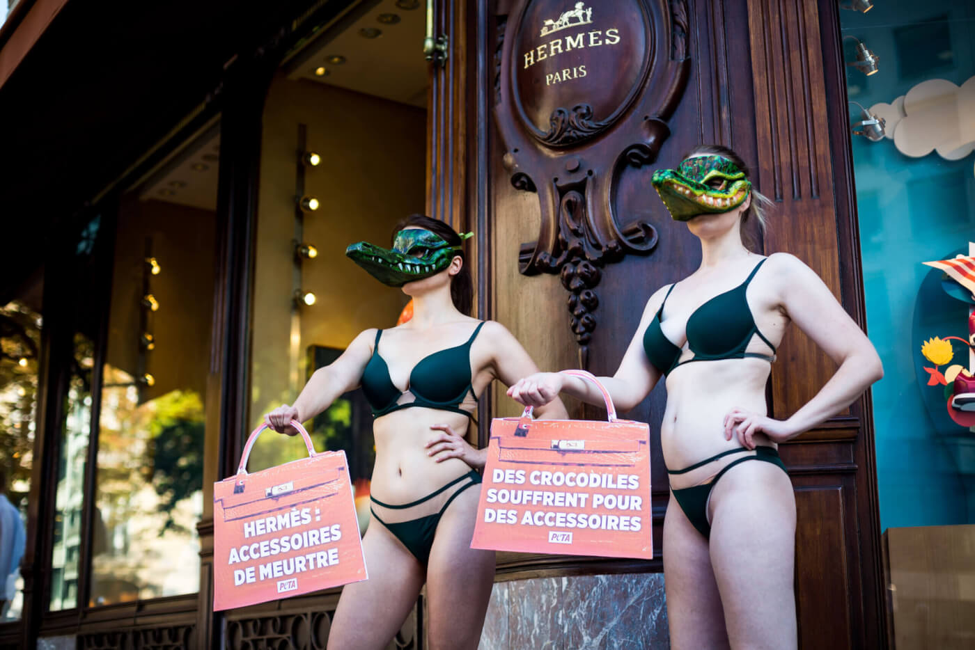 Activists wearing bikinis and crocodile masks protest at Hermès in Paris.