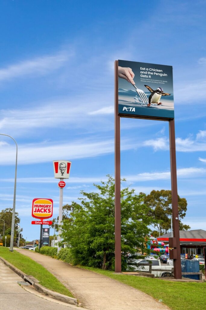 The ad depicts a baby penguin running from a giant fork, and reads “Eat a Chicken and The Penguin Gets It. Factory Farms Are Incubators for Deadly Diseases Which Are Killing Wild Birds”.