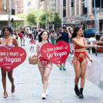 PETA activists at Town Hall in Sydney. Signs read: "Have a Heart Go Vegan," and "I Love People Who Love Animals"