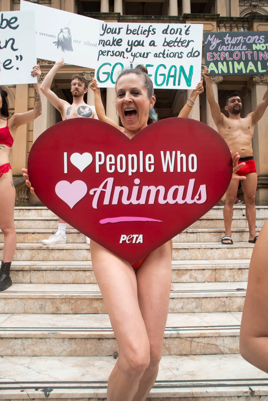 Activist covered by sign that reads "I love people who love animals"