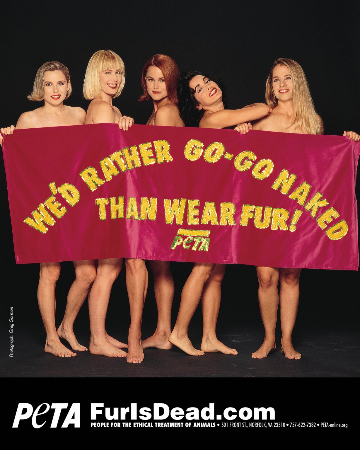 A photo of The Go Gos behind a banner that reads "We'd Rather Go-Go Naked Than Wear Fur!"