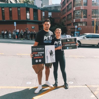 A photo of two activists protesting outside Victoria University of Wellington.