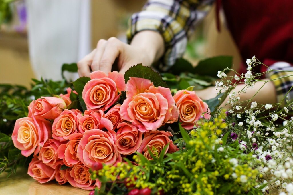 A photo of flowers being arranged on a table.