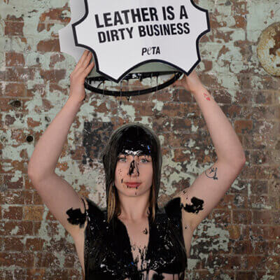 PETA supporters pour buckets of black “toxic slime” – representing the harmful waste generated by the leather industry – over their heads at Fashion Week.