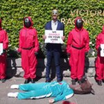 Activists recreate a scene from Squid Game at the gates of Flemington