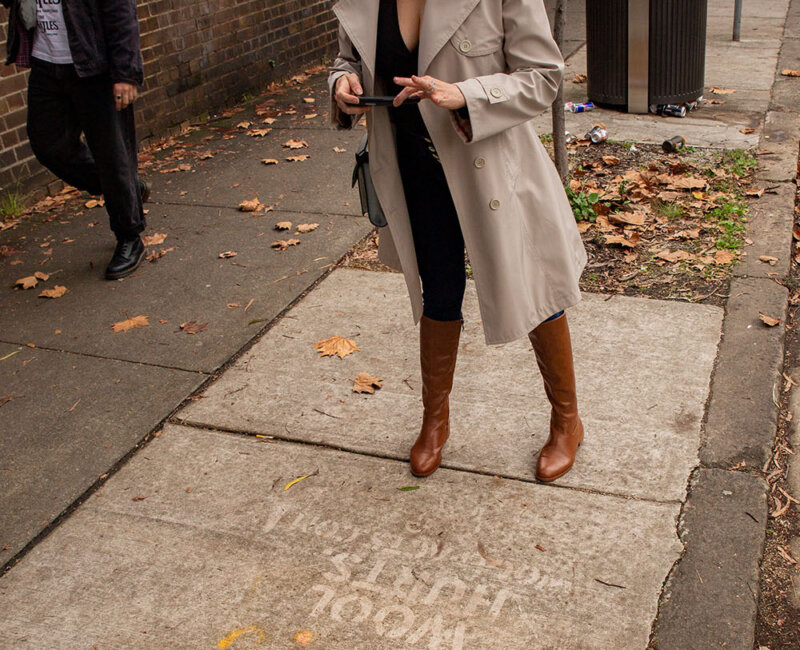 a woman takes a photo of a street stencil at Australian Fashion Week in Sydney